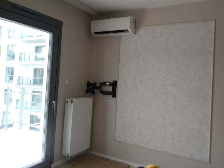 Biały klimatyzator na popielatej ścianie w mieszkaniu